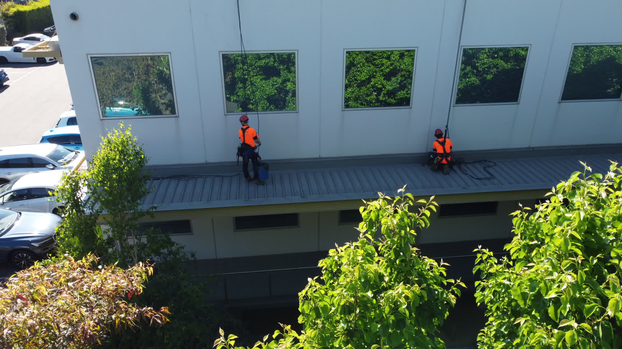 Aerial view of rope access technicians working on a commercial roof