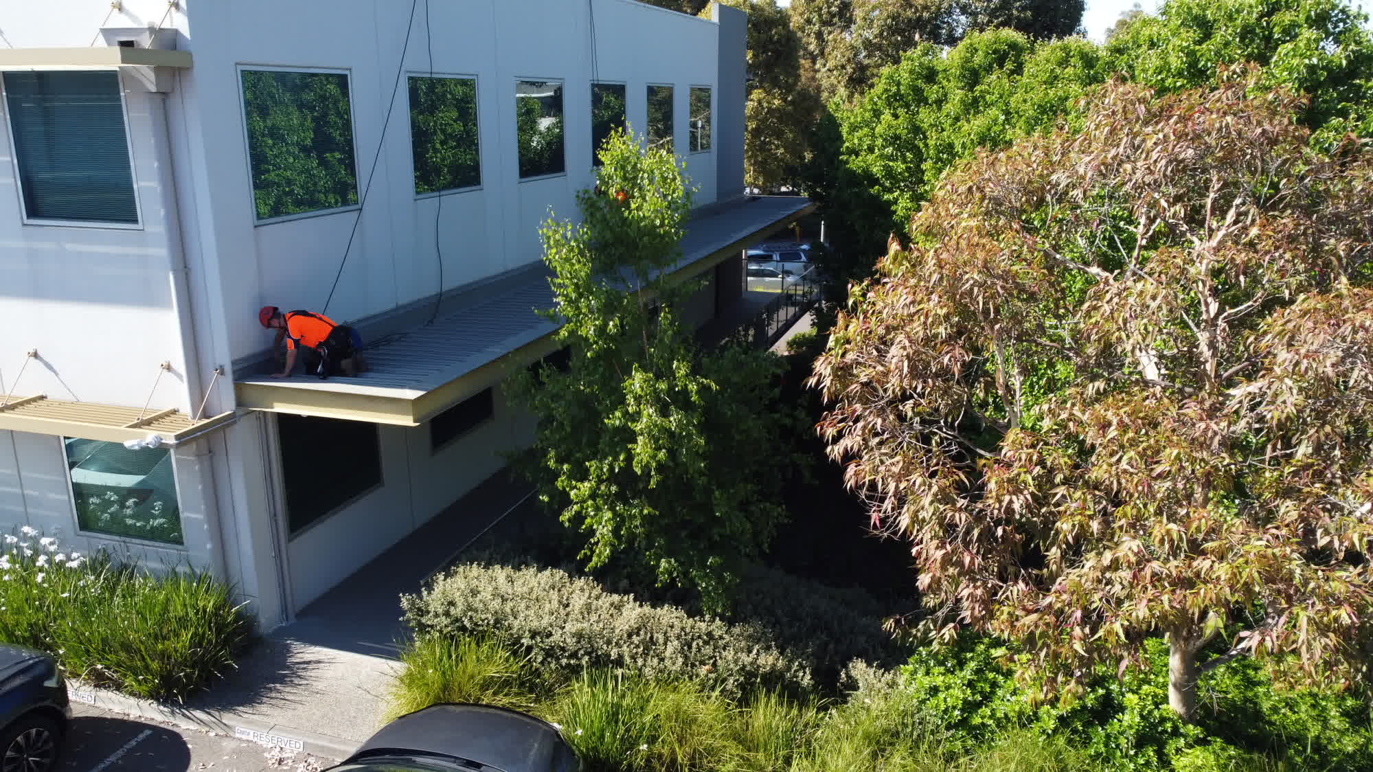 Aerial view of a rope access worker on a commercial roof
