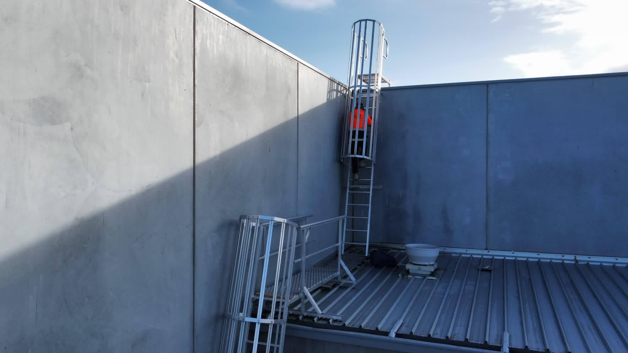 Caged access ladder providing safe roof access on a commercial building